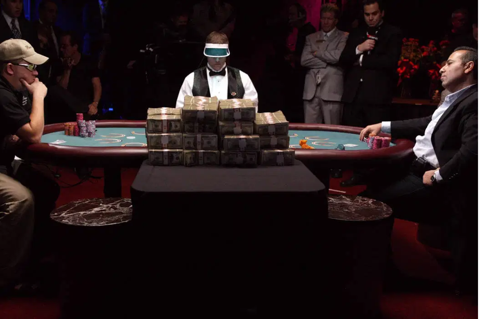 intense poker table with head to head action and a lot of cash piled in the middle.